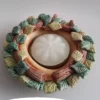 Immagine che rappresenta il portacandele artistico in ceramica "Due rami" con una candelina spenta al centro