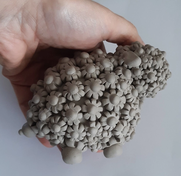 Pecorella sarda stilizzata in ceramica, decorata con l'ispirazione alla filigrana sarda, non ancora cotta né colorata